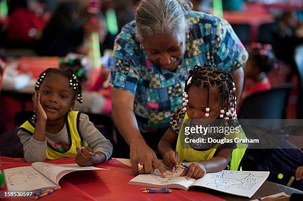 Dec 18 : Linda Walton of the Edward C. Mazique Parent Child Center helps some little ones with coloring during the Covenant House 22nd Annual "D.C....