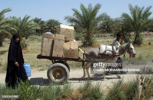 Displaced Iraqi Shiites carry aid on a donkey cart as they leave a relief center in Karbala, south of Baghdad, 23 September 2007. Nearly two million...