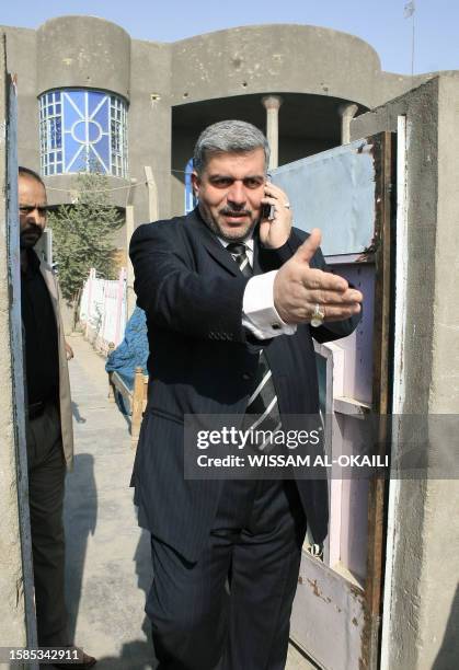 Iraqi member of parliament Falal Hassan Chanchal talks on his mobile phone in front of his house in the Shiite slum of Sadr City in Baghdad, 30...
