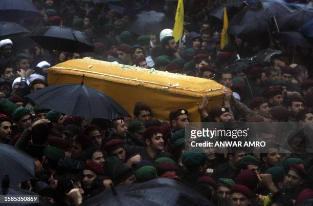 Hezbollah commandos carry the coffin of assassinated commander Imad Mughnieh through the rain during his funeral procession in Beirut's mainly Shiite...