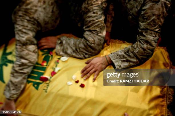 Shiite Muslim Hezbollah militants touch the coffin of assassinated Hezbollah commander Imad Mughnieh, prior to his funeral in Beirut's mainly Shiite...