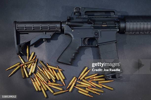 In this photo illustration, a Rock River Arms AR-15 rifle is seen with ammunition on December 18, 2012 in Miami, Florida. The weapon is similar in...