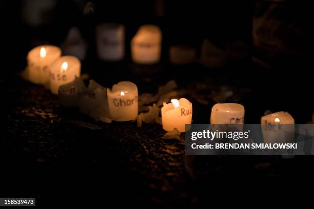 Candles with the names of victims of the Sandy Hook Elementary School shooting written on them are seen at a makeshift memorial near the entrance to...