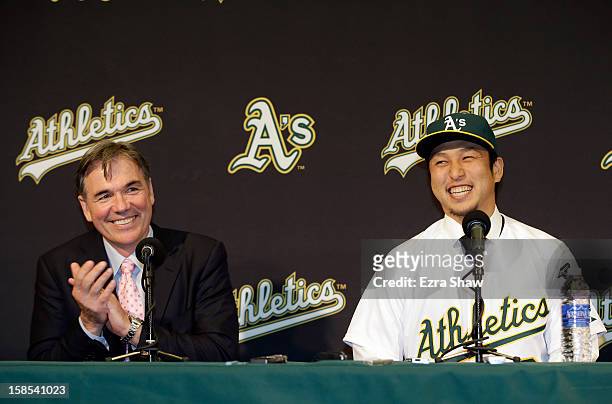 Oakland Athletics vice president and general manager Billy Beane and Hiroyuki Nakajima of Japan joke with each other at a press conference where...