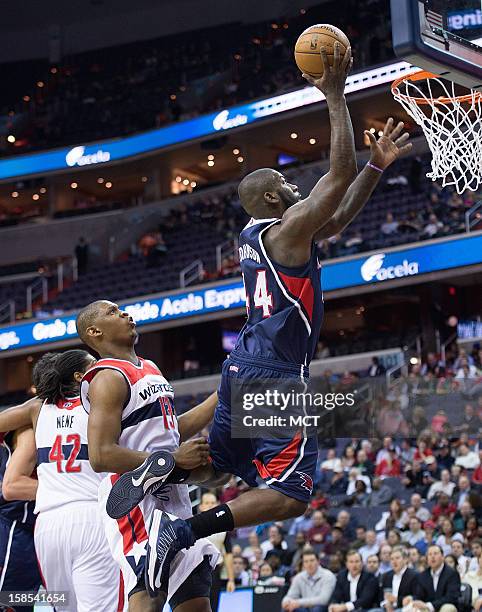 Atlanta Hawks power forward Ivan Johnson scores over Washington Wizards power forward Kevin Seraphin during the first half of their game played at...