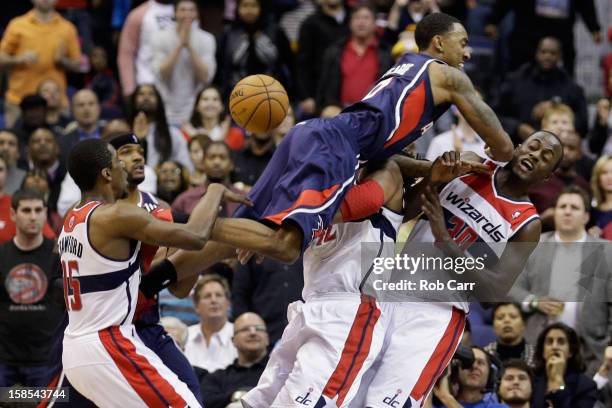 Jeff Teague of the Atlanta Hawks is called for an offensive foul while going to the basket against Jordan Crawford, Nenê, and Earl Barron of the...