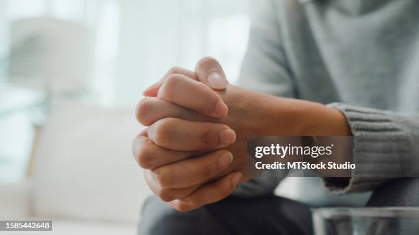 closeup of young asian female psychotherapist discussing a problem and touch hand young depressed sit on couch at clinic. medical insurance, mental health. - despair stock pictures, royalty-free photos & images