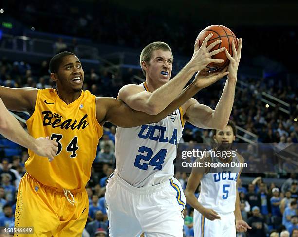 Travis Wear of the UCLA Bruins fights for the ball with Kyle Richardson of the Long Beach State 49ers at Pauley Pavilion on December 18, 2012 in Los...