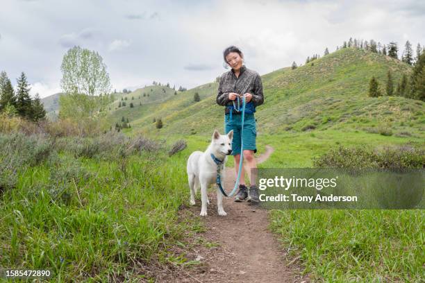 young woman walking her dog on a leash - sun valley idaho stock pictures, royalty-free photos & images