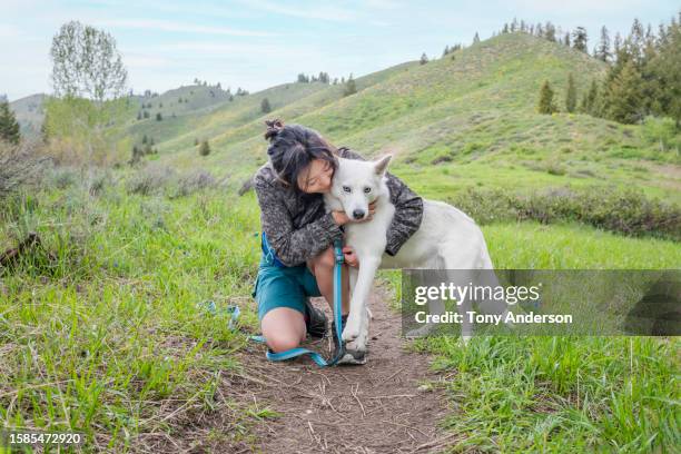 young woman hugging her dog while on walk - korean ethnicity stock pictures, royalty-free photos & images