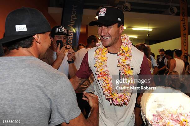 Australian surfer Joel Parkinson is congratulated by Dean Morrison as he arrives home at the Gold Coast airport on December 19, 2012 on the Gold...