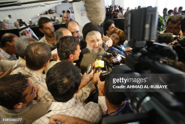 Sheikh Hussein Sadr is surrounded by journalists at the Iraqi national conference at the Baghdad convention center 17 August 2004. Delegates from the...