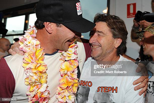 Australian surfer Joel Parkinson is congratulated by his uncle Daryl Parkinson as he arrives home at the Gold Coast airport on December 19, 2012 on...