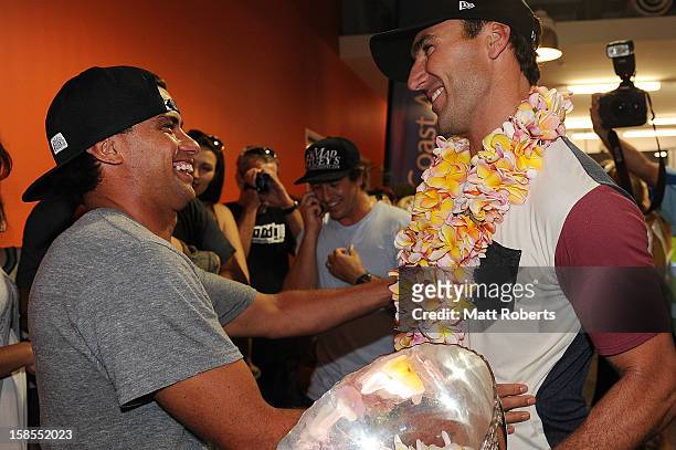 Australian surfer Joel Parkinson is congratulated by Dean Morrison as he arrives home at the Gold Coast airport on December 19, 2012 on the Gold...