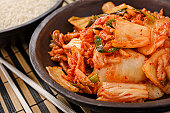 Plate full of kimchi and chopsticks on side