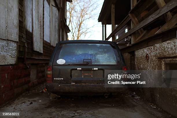 Car destroyed by flood waters sits in the driveway of a damaged home in the Rockaway neighborhood on November 19, 2012 in the Queens borough of New...
