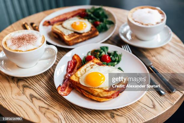 croque madame sandwich with bacon served for breakfast in a restaurant, side view - setzei stock-fotos und bilder