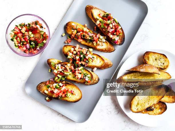 platter of tomato bruschetta on white background - bruschetta stock pictures, royalty-free photos & images