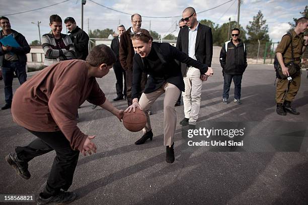 Israel's former foreign minister Tzipi Livni, now head of the new political party 'The Movement' plays basketball during a campaign tour on December...