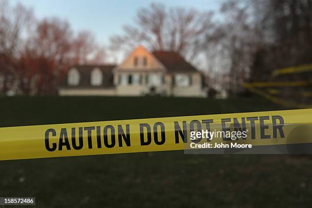 Police tape stretches across the front yard of the Lanza residence on December 19, 2012 in Newtown, Connecticut. Adam Lanza reportedly shot his...