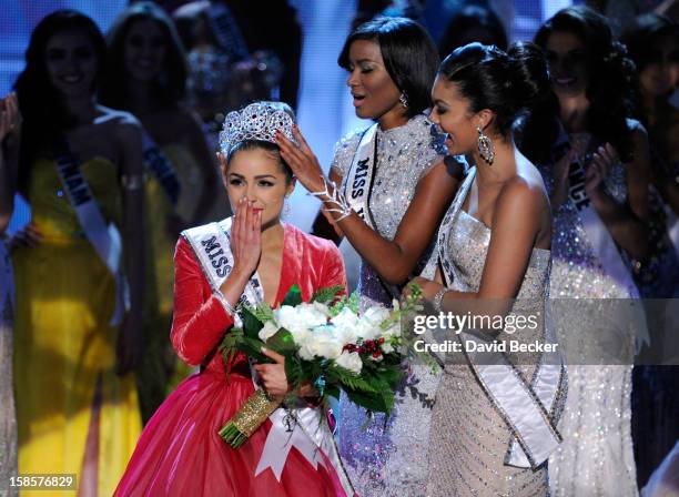Miss USA 2012, Olivia Culpo, is crowned the 2012 Miss Universe by Leila Lopes, Miss Universe 2011, as Logan West, Miss Teen USA 2012, looks on during...