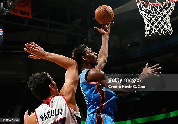 Hasheem Thabeet of the Oklahoma City Thunder drives against Zaza Pachulia of the Atlanta Hawks at Philips Arena on December 19, 2012 in Atlanta,...