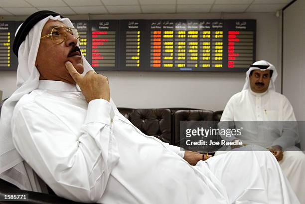 Stock investor Nijil Nijil Adula and Jehad Ameen watch their investments in the stock exchange room November 4, 2002 in Manama, Bahrain. With a...