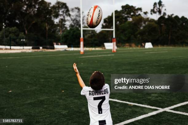 Young player throws the rugby ball while wearing a shirt of the Portuguese football player Cristiano Ronaldo while attending Direito's Summer Academy...
