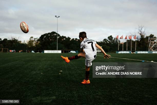 Young player kicks the rugby ball while wearing a shirt of the Portuguese football player Cristiano Ronaldo while attending Direito's Summer Academy...