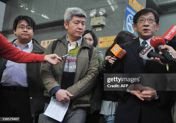 Lawyer Huang Kuo-chen and rights activist Ho Tsung-hsun look on as lawyer Huang Kuo-cheng speaks to reporters about a court ruling on gay marriage...