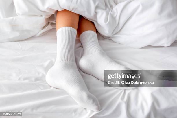 feet of a boy in white socks lying on a bed - kids white socks stock pictures, royalty-free photos & images