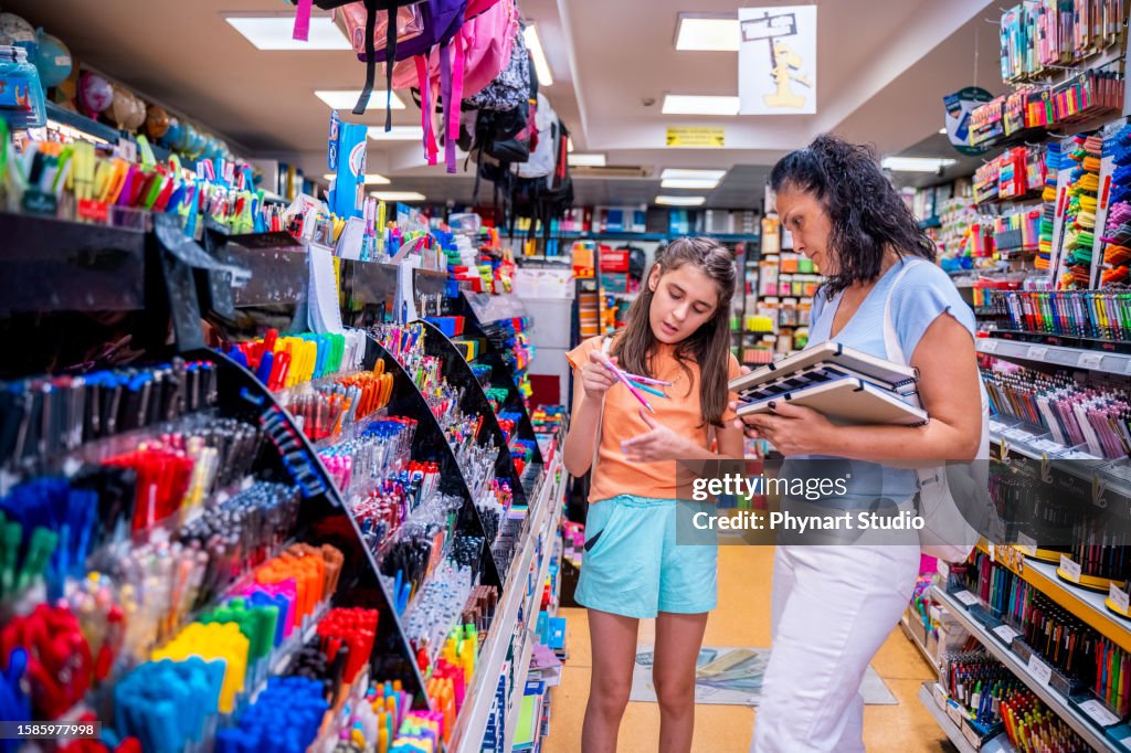 Mother and daughter shopping school supplies in a store