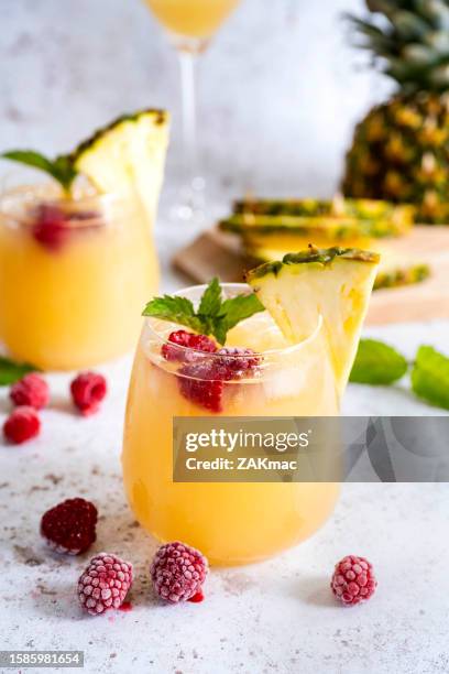 cocktails with pineapple juice and rasberries - stock photo - raspberry cocktail stock pictures, royalty-free photos & images