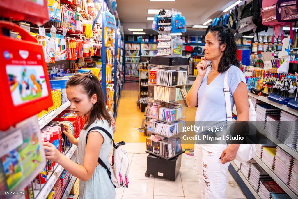 Mother and daughter shopping school supplies in a store