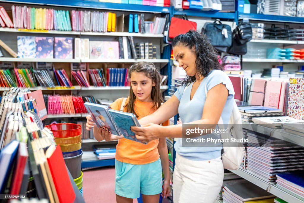 Mother and daughter shopping school supplies in a store
