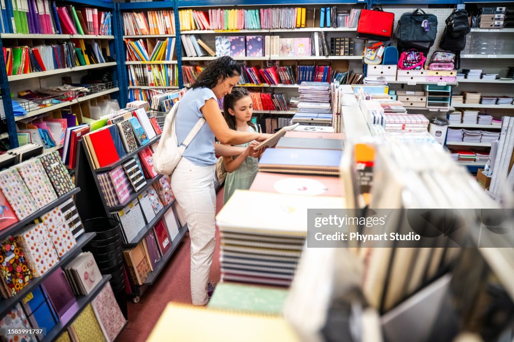 Mother and daughter shopping school supplies in a store