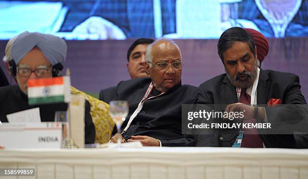 Indian Prime Minister Manmohan Singh speaks as Indian Agriculture Minister Sharad Pawar and Commerce and Trade Minister Anand Sharma look on during...