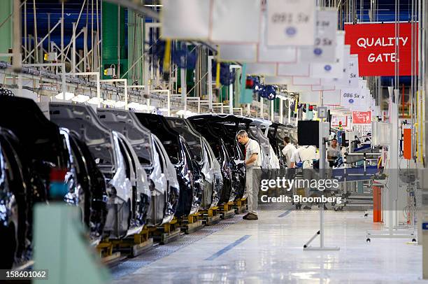Employees assemble Punto automobiles as they travel along the production line at the Fiat SpA plant in Melfi, Italy, on Thursday, Dec. 20, 2012. Fiat...