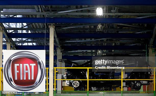Fiat Punto automobile stands next to a logo during assembly at the Fiat SpA plant in Melfi, Italy, on Thursday, Dec. 20, 2012. Fiat SpA, the Italian...