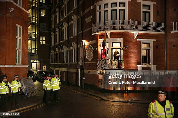 Police watch as Wikileaks founder Julian Assange speaks from the Ecuadorian Embassy on December 20, 2012 in London, England. Mr Assange has been...