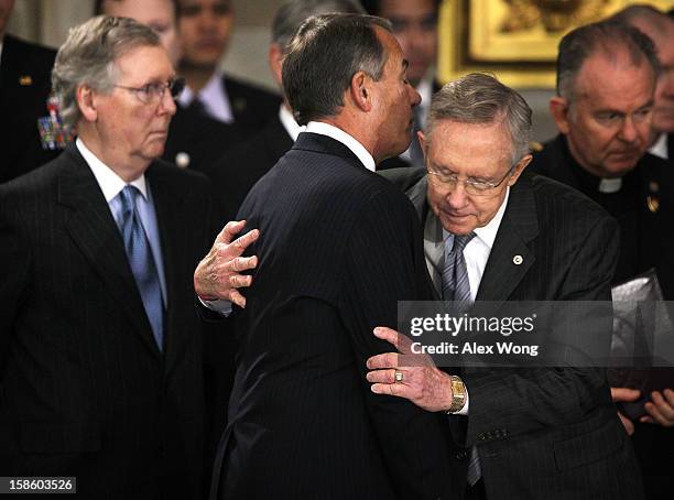 Senate Majority Leader Sen. Harry Reid hugs Speaker of the House Rep. John Boehner as Senate Minority Leader Sen. Mitch McConnell looks on as Senator...