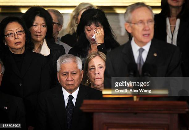 Family member wipes her tears as U.S. Senate Majority Leader Sen. Harry Reid speaks as Senator Daniel Inouye lies in state in the Rotunda of the U.S....