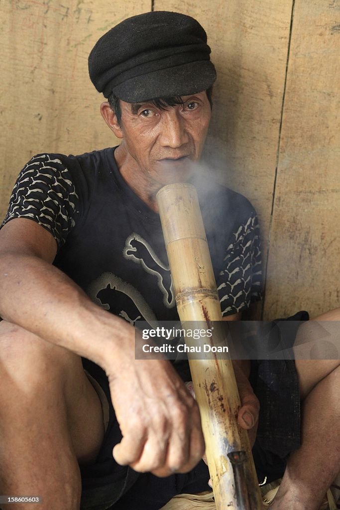An ethnic minority H'mong man smokes tobacco while waiting...