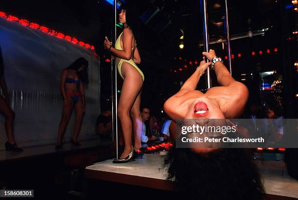 Scene from a Go-Go bar in the red-light district of Patpong. Bar girls dance on stage for customers. Most of these women are sex-workers. .