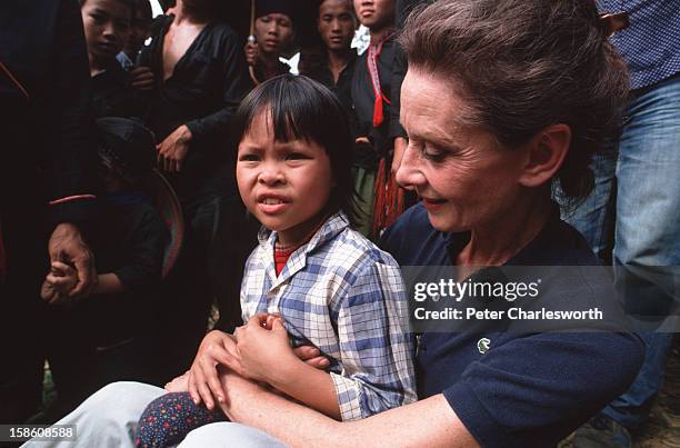 Audrey Hepburn, UNICEF's Goodwill Ambassador, holds a small girl while visiting a small village close to Hanoi..