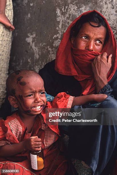 Woman and her child sit in a cyclone shelter waiting for emergency relief after surviving one of the biggest cyclones to hit Bangladesh in recent...