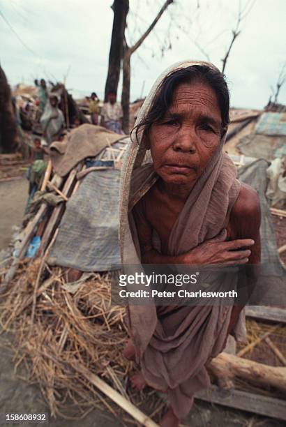 An old woman walks in front of a hastily-erected shelter, built after one of the biggest cyclones to hit Bangladesh in recent decades had totally...
