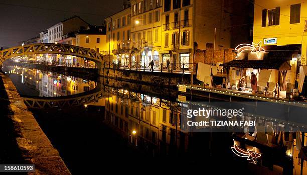People walk near a nativity crib dispalyed at the 'Navigli' in Milan on December 20, 2012. The 'Navigli' are artificials canals built from the 12th...