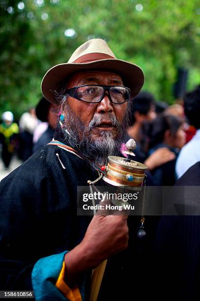 Tibetan man turns his prayer wheel during the Sho Dun Festival in Norbulingka on August 18, 2012 in Lhasa, China. Lhasa is the administrative capital...