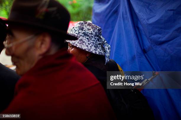 Tibetan woman carries a toy gun in her backpack beside a monk during the Sho Dun Festival in Norbulingka on August 18, 2012 in Lhasa, China. Lhasa is...